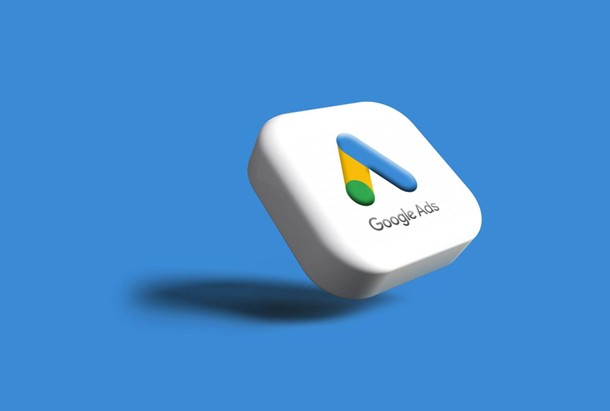 3D icon of the Google Ads logo on a white rounded cube, floating above a blue background with a soft shadow beneath.